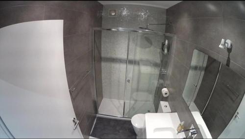 a bathroom with a shower and a toilet and a sink at T3 Vilamoura in Vilamoura