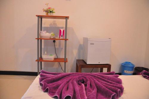 a purple blanket laying on top of a bed at Sigiri Saman Home Stay in Sigiriya