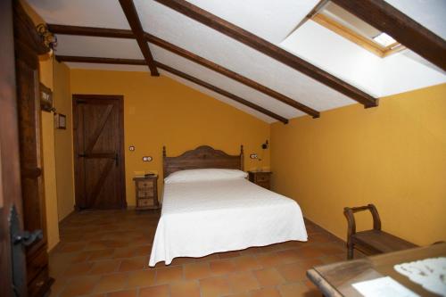 ein Schlafzimmer mit einem weißen Bett in einer gelben Wand in der Unterkunft Hotel Posada San Antonio in El Bosque