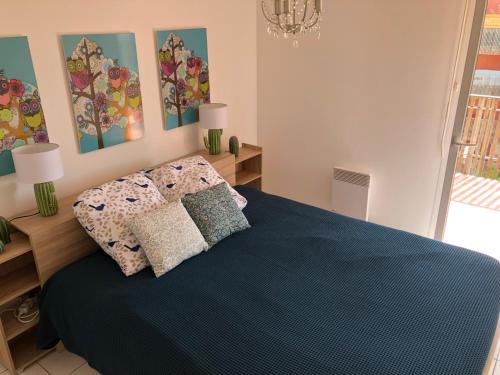 una camera da letto con un letto blu con due cuscini di Bleu de Thau a Balaruc-les-Bains