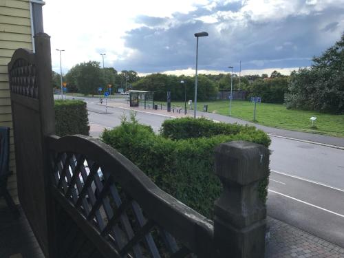 a wooden fence next to a street with a park at BoSmart Apartments in Gothenburg