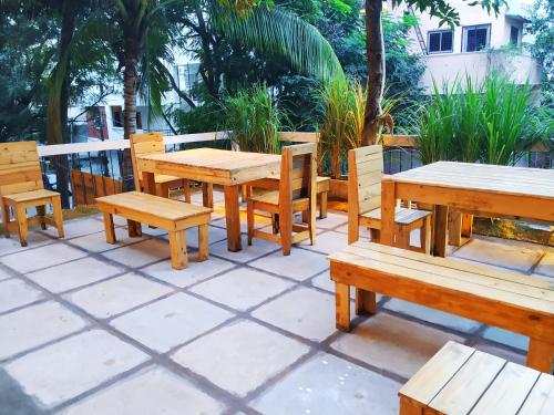 a group of wooden tables and benches on a patio at Shepherd Stories - Community stay for Social Entrepreneurs in Hyderabad