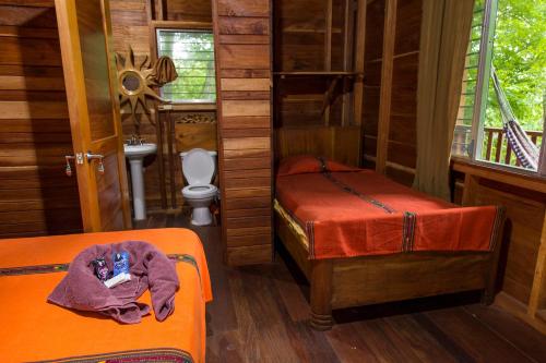 a room with two beds and a bathroom with a toilet at Hotel Mon Ami in El Remate