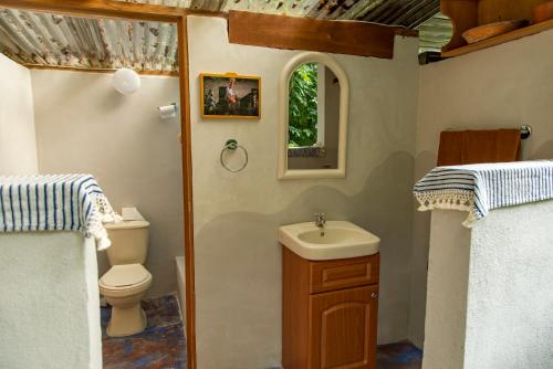 a small bathroom with a toilet and a sink at Hotel Mon Ami in El Remate