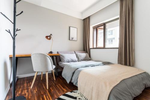 a bedroom with a bed and a desk and a chair at Wuhan Hongshan·Jiedaokou· Locals Apartment 00116860 in Wuhan