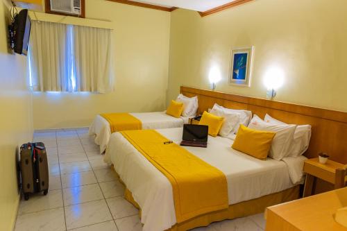 a hotel room with two beds with a laptop on it at Hotel Vermont Ipanema in Rio de Janeiro