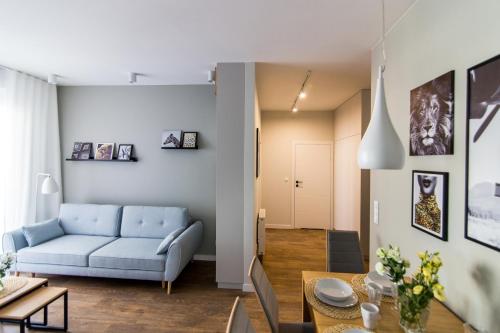 a living room with a blue couch and a table at Apartamenty City Tower od WroclawApartament-pl in Wrocław