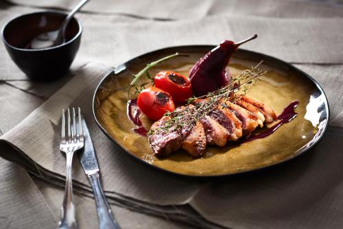 a plate of food with meat and vegetables on a table at Rossano Boutique Hotel & Ristorante in Ansbach