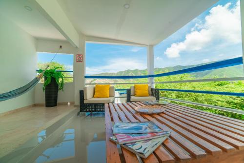 ein Wohnzimmer mit einem Tisch und einem großen Fenster in der Unterkunft Techos Azules in Taganga