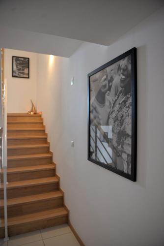 a television hanging on a wall next to a staircase at Guesthouse Le Châtelain in Santa Maria