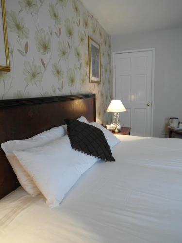 a bed with a black and white pillow on it at Best Western The George Hotel, Swaffham in Swaffham