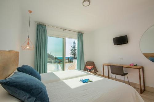 a bedroom with a bed with a window and a desk at Fortuna in Los Caños de Meca