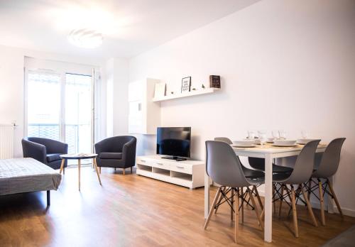 a living room with a table and chairs and a television at Apartamenty City Tower od WroclawApartament-pl in Wrocław