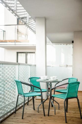 a group of chairs and a table on a balcony at Apartamenty City Tower od WroclawApartament-pl in Wrocław