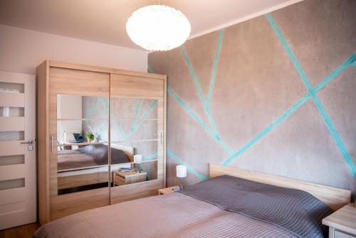 a bedroom with a bed with a painting on the wall at Apartamenty City Tower od WroclawApartament-pl in Wrocław