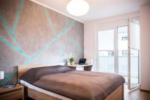 a bedroom with a bed and a wall with green lines at Apartamenty City Tower od WroclawApartament-pl in Wrocław