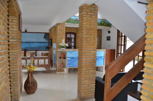a living room with a brick pillar and a vase at Pousada Grauça in Cacha Pregos