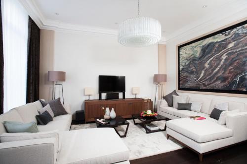 uma sala de estar com dois sofás brancos e uma televisão em Claverley Court Apartments Knightsbridge em Londres