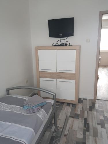 um quarto com uma cama e uma televisão na parede em Ferienhaus Thalia 2 em Übach-Palenberg