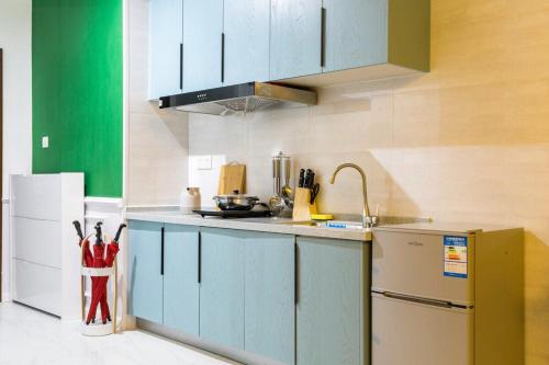 a kitchen with blue cabinets and a refrigerator at Wuhan Wuchang·Qunxingcheng Square · Locals Apartment 00121920 in Wuhan