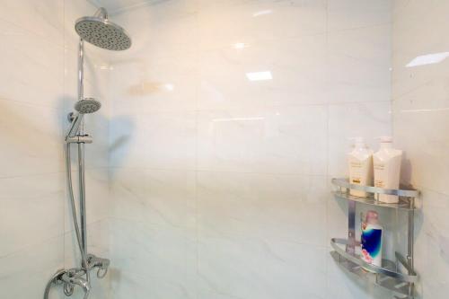 uma casa de banho com um chuveiro e uma porta de vidro em Wuhan Wuchang·Qunxingcheng Square · Locals Apartment 00121920 em Wuhan