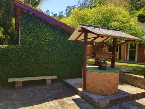 un banco y un pabellón frente a un edificio en Pousada Ypê das Montanhas, en Monte Alegre do Sul