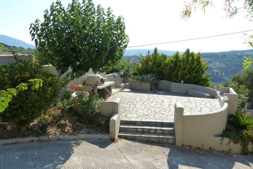 a garden with stairs and a table and trees at Knossos Palace Secluded Villa in Skalánion