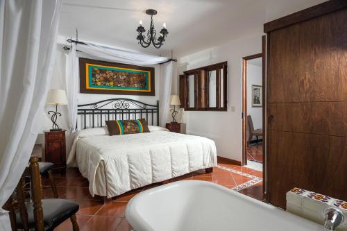 a bedroom with a bed and a tub in it at Hotel Tapalpa de Mis Amores in Tapalpa