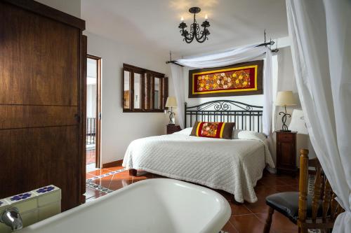 a bedroom with a bed and a bath tub at Hotel Tapalpa de Mis Amores in Tapalpa