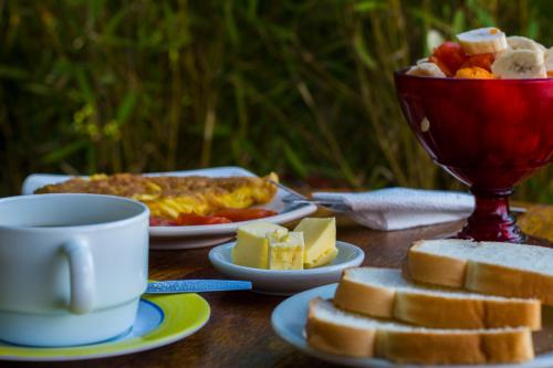 a table with plates of food and a cup of coffee at Blue House Youth Hostel in Quito