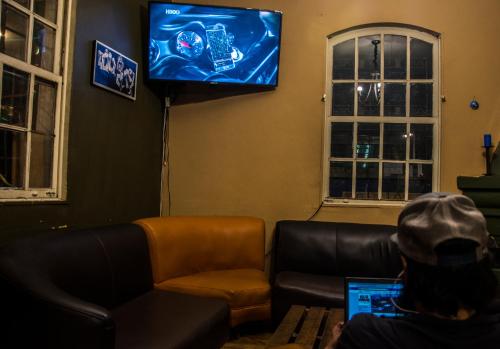 a person sitting on a couch with a laptop at Blue House Youth Hostel in Quito
