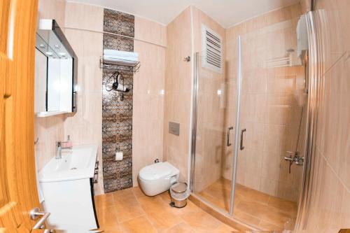 a bathroom with a shower and a toilet and a sink at Kerpe Diem Otel in Kerpe
