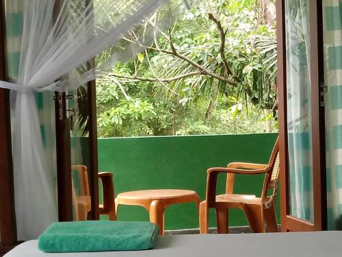 a room with two chairs and a green wall at Unawatuna Backpacker Lodge in Unawatuna
