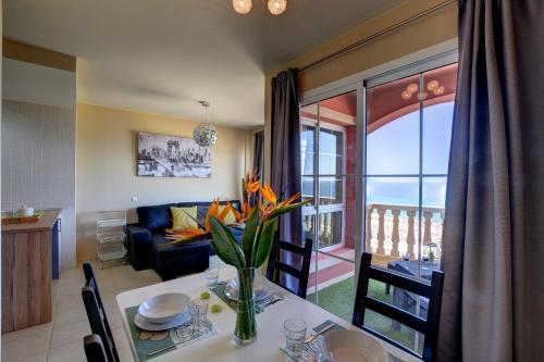 una sala de estar con una mesa con un jarrón de flores en Amanecer Paraíso, en Costa Calma