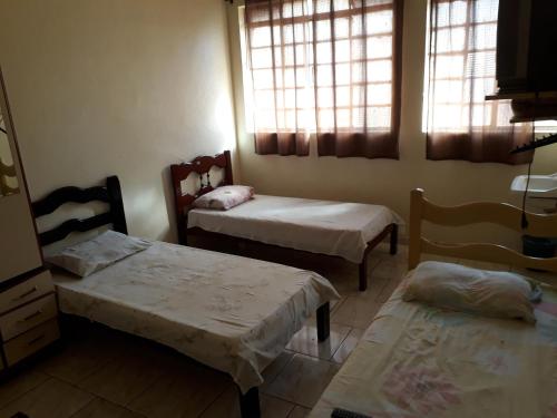 Habitación pequeña con 2 camas y 2 ventanas en Hotel Santa Marta, en Ribeirão Preto