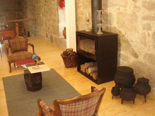 a living room with a fireplace and a table and chairs at Casa da Ponte do Porto in Amares