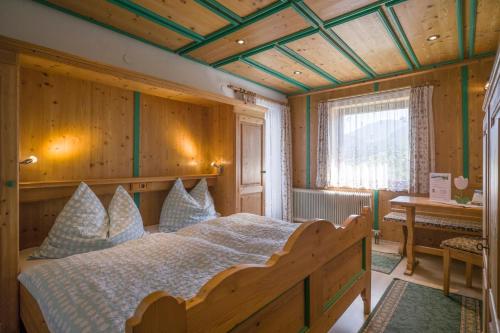ヴァルヒゼーにあるSteindlhof in Walchseeの木製の天井が特徴のベッドルーム1室(ベッド1台付)