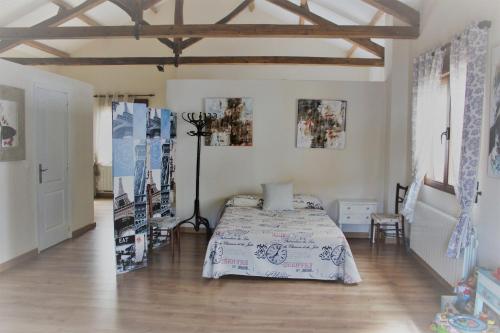 Un dormitorio con una cama en una habitación con suelo de madera. en Casa Rural Los Montones, en Carcelén