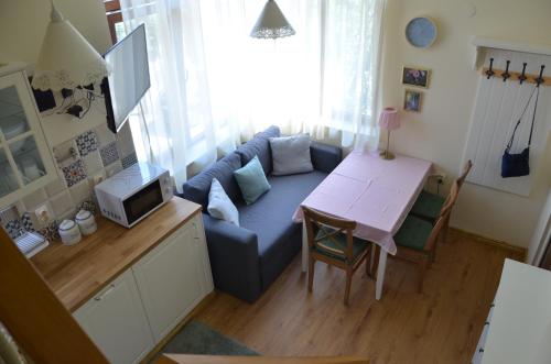 a living room with a blue couch and a table at Our House In The Town in Veliko Tŭrnovo