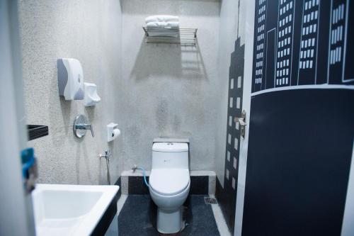 a bathroom with a white toilet and a sink at DJ Citi Point Hotel in Kuala Terengganu