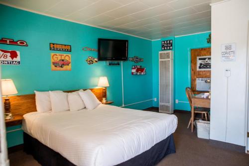 
a bedroom with a bed and a television at Historic Route 66 Motel in Seligman
