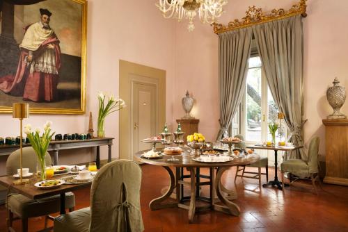 a dining room with a table with food on it at Al Palazzo del Marchese di Camugliano Residenza d'Epoca in Florence