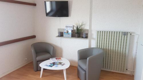 a room with two chairs and a table and a tv at Roscoff Les Duons in Roscoff