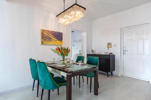 a dining room with a table and green chairs at Wuhan Wuchang·Wuchang River Beach· Locals Apartment 00139250 in Wuhan