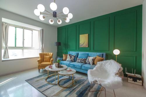 a living room with green walls and a blue couch at Wuhan Wuchang·Wuchang River Beach· Locals Apartment 00139250 in Wuhan