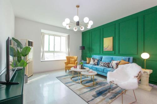 a living room with a blue couch and green walls at Wuhan Wuchang·Wuchang River Beach· Locals Apartment 00139250 in Wuhan