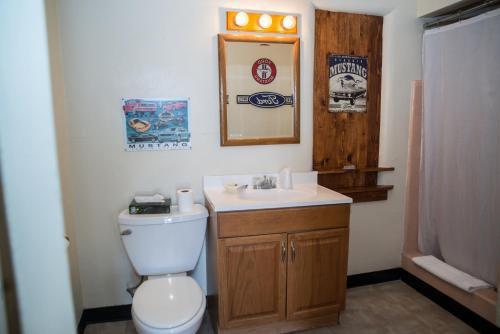 a bathroom with a toilet and a sink and a mirror at Historic Route 66 Motel in Seligman