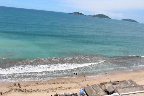 a beach with people standing in the water at Hotel Playa Marina in Mazatlán