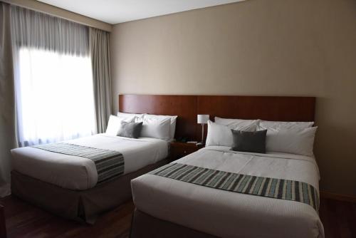 Postel nebo postele na pokoji v ubytování Howard Johnson Resort & Spa Escobar