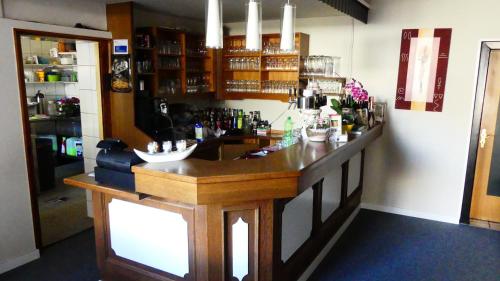 un bar con barra de madera en una habitación en Hotel Zum Böhmegrund, en Bad Fallingbostel